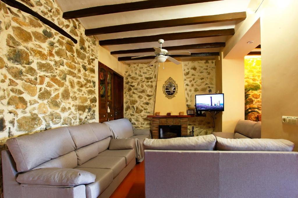 Salón con paredes de piedra, vigas de madera y chimenea